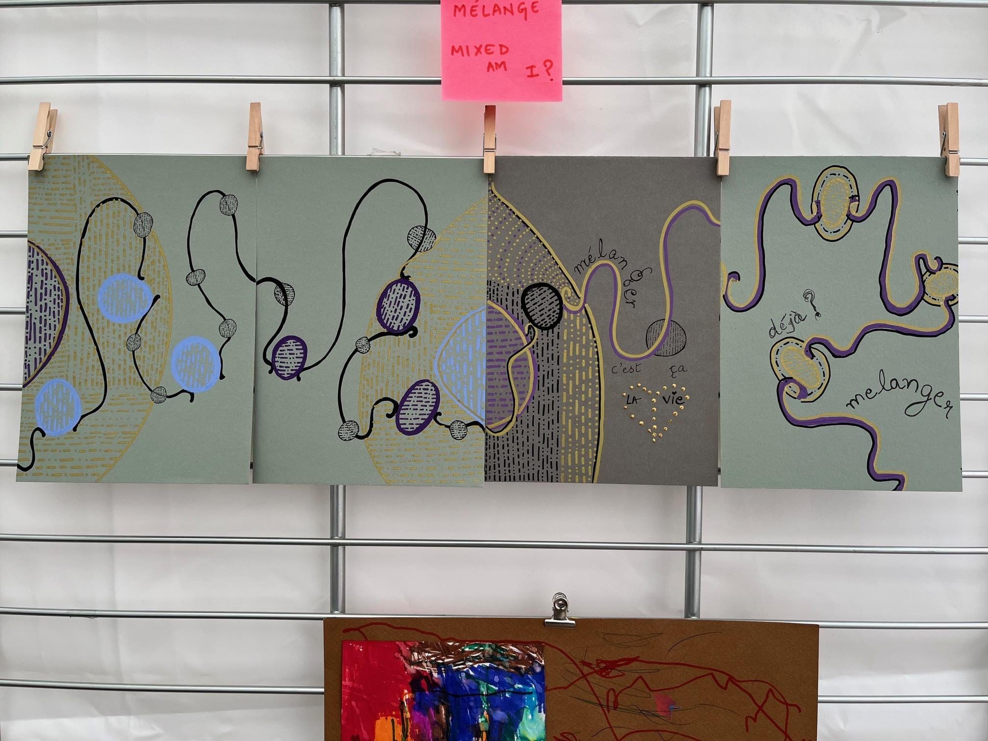 Mélanger, av Anujalika. Fem grå kartonger uppnålade på rad på ett galler, var och en broderad med slingrande linjer, blå och lila punkter och orden c'est ça la vie och mélanger.